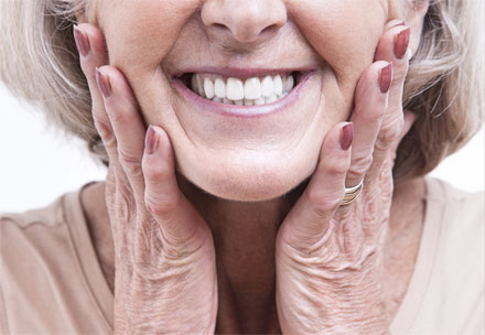 Ältere Dame mit einem strahlenden Lächeln und wunderschönen Zähnen