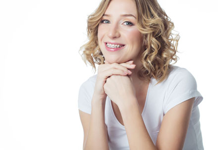 Lächelnde junge Dame die eine Zahnspange trägt